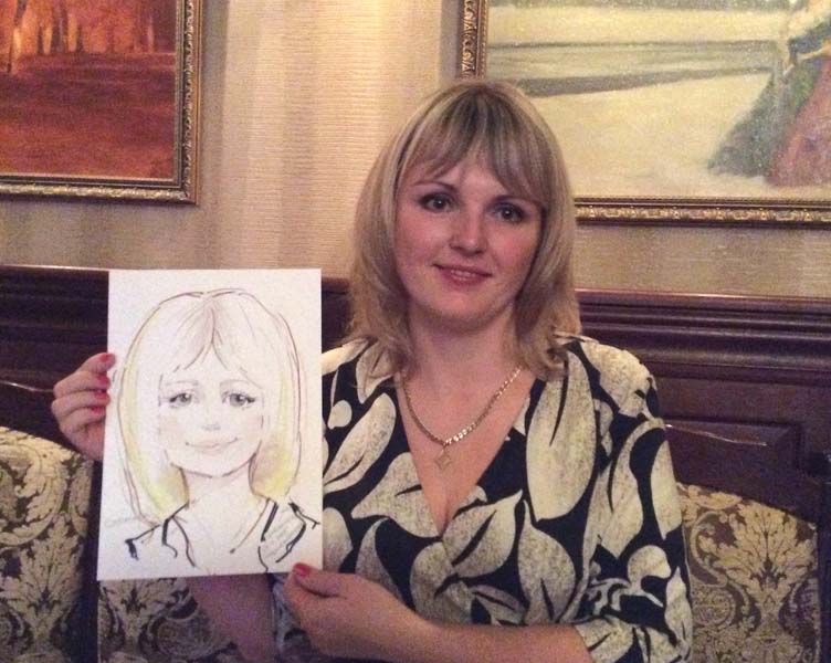 Снежана позирует шаржисту в ресторане на фоне картины