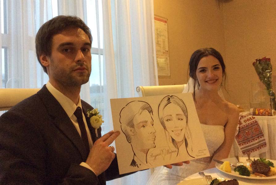 Андрей и Мария позируют шаржисту на своей свадьбе