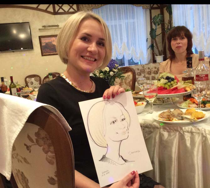 Светлана радуется своему нарисованному шаржу на свадьбе