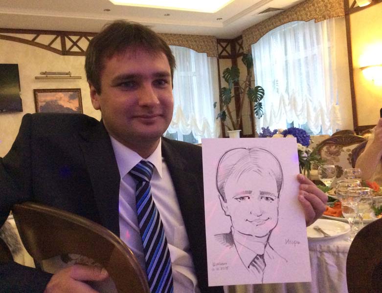 Игорь доволен полученным от шаржиста рисунком