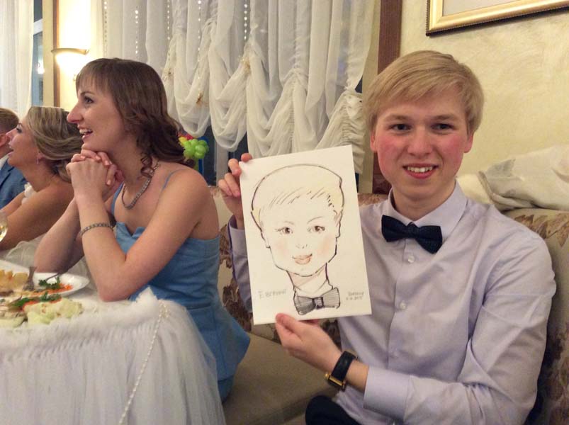 Евгений показывает свой шарж на свадьбе