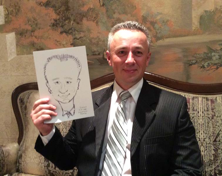 Александр позирует шаржисту в 